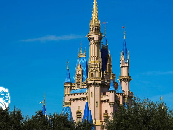 Cinderella Castle's blue and gold spires rising above lush green trees at Magic Kingdom Park.