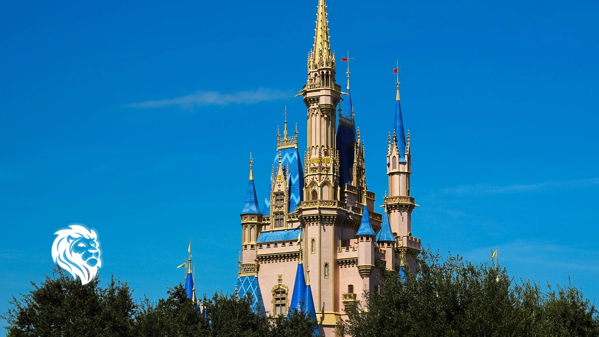 Cinderella Castle's blue and gold spires rising above lush green trees at Magic Kingdom Park.