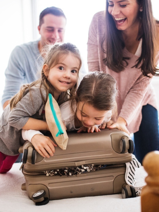 Young,Family,With,Two,Children,Packing,For,Holiday.