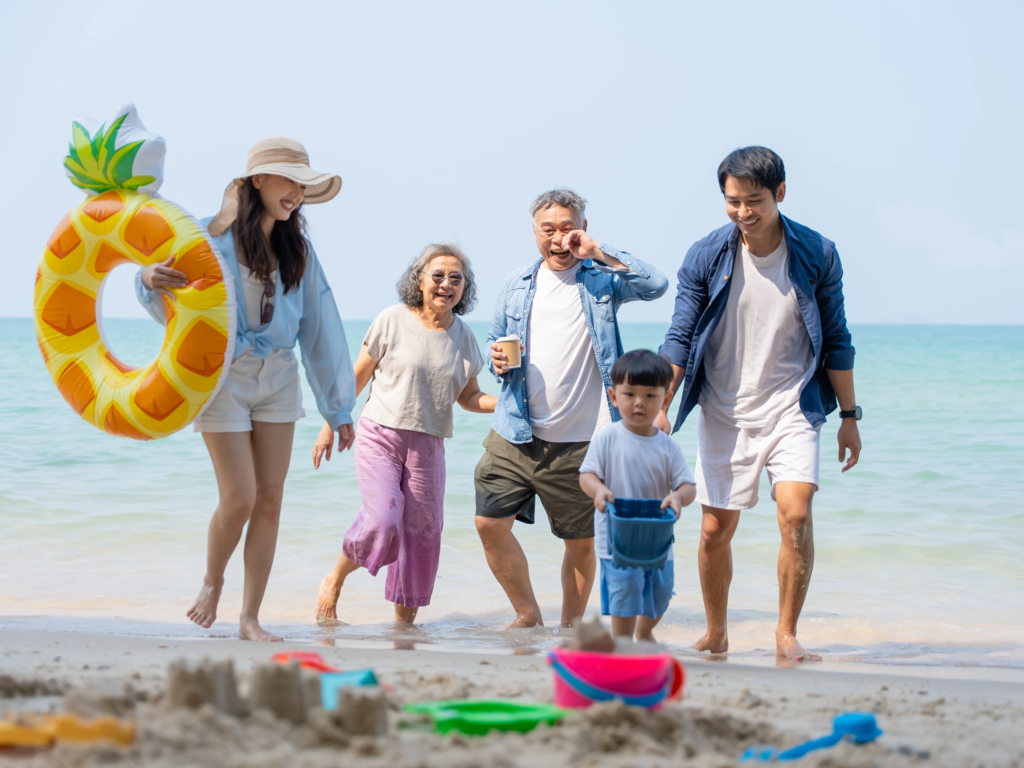Multigenerational family walking and playing together on a sunny beach, enjoying timeshare values over time.