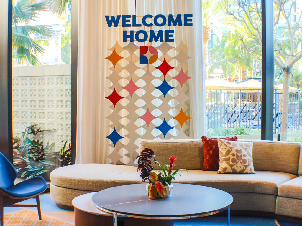 Modern lobby lounge at The Villas at Disneyland Hotel featuring mid-century furniture and colorful wall art.