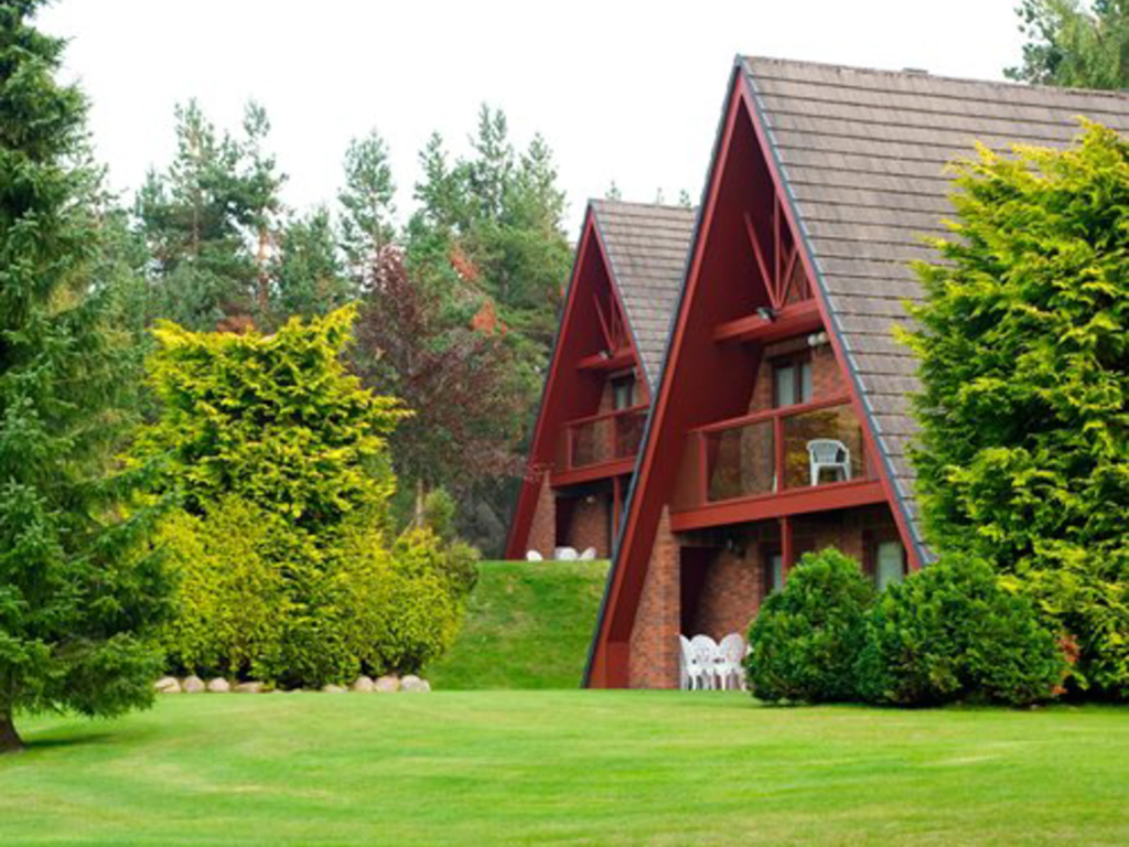 Cozy A-frame timber lodges nestled on a green lawn at Coylumbridge, funded via Hilton timeshare financing.