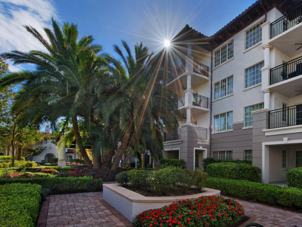Sunny exterior view of Marriott's Lakeshore Reserve villas framed by tropical palm trees and gardens.