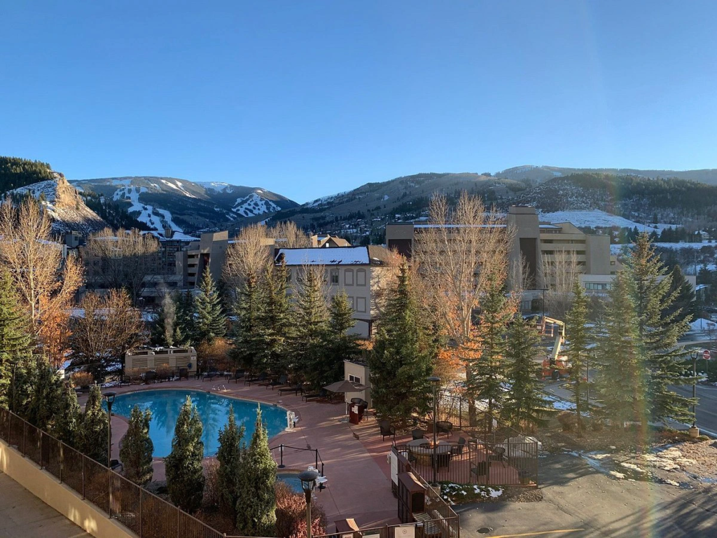 Scenic balcony view of the outdoor swimming pool and snowy peaks at Sheraton Mountain Vista.