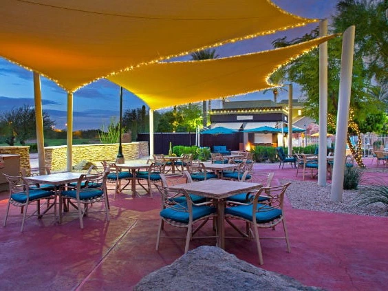 Outdoor patio dining area under illuminated sun sails at Marriott's Canyon Villas at nightfall.