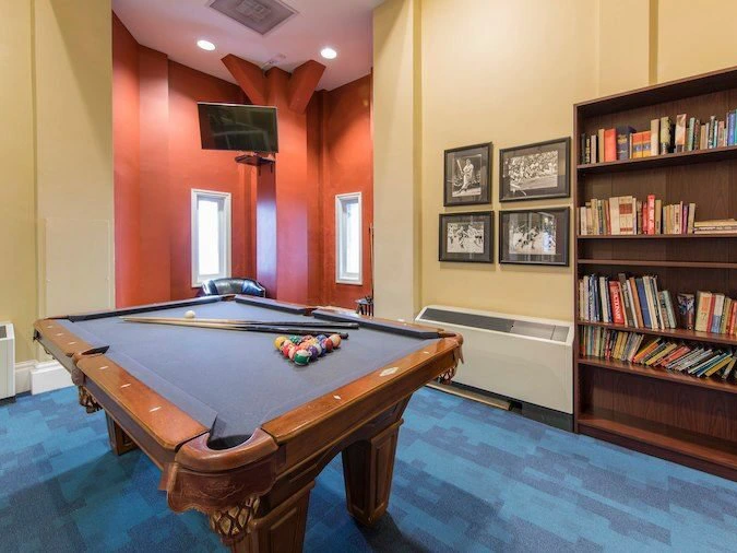 A classic game room featuring a billiards pool table and large bookcase at Marriott's Custom House.