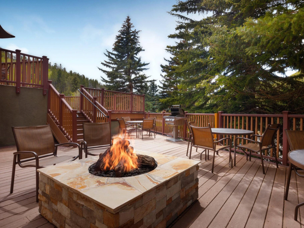 Relaxing outdoor wooden deck with a warm stone firepit and seating at Marriott's StreamSide resort.