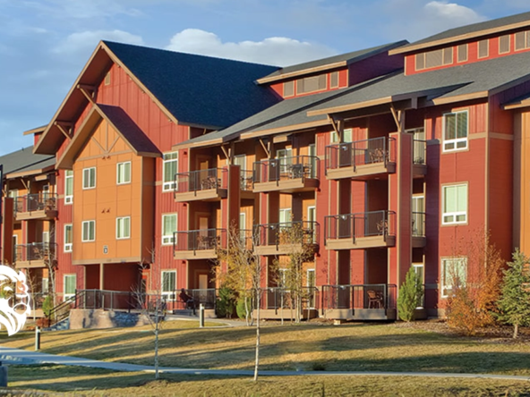 Exterior view of the multi-story red and orange lodge-style buildings at WorldMark West Yellowstone.