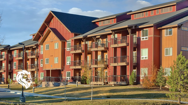 Exterior view of the multi-story red and orange lodge-style buildings at WorldMark West Yellowstone.