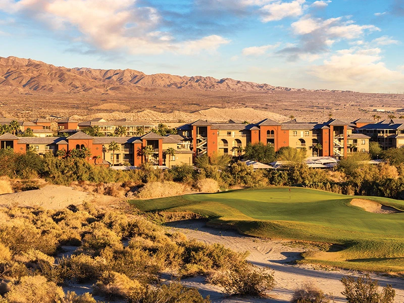 Sell Wyndham Points – a golf course with a large green area, surrounded by desert and mountains in the background.