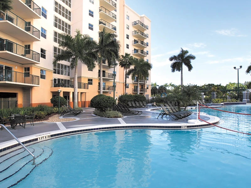 Outdoor swimming pool with a volleyball net at Club Wyndham Palm-Aire resort.