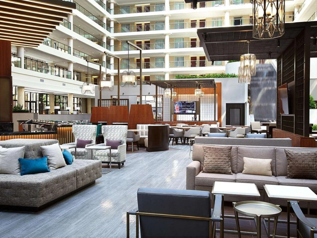 The contemporary, upscale interior lobby of The District by Hilton Club in Washington D.C., featuring modern lounge seating.