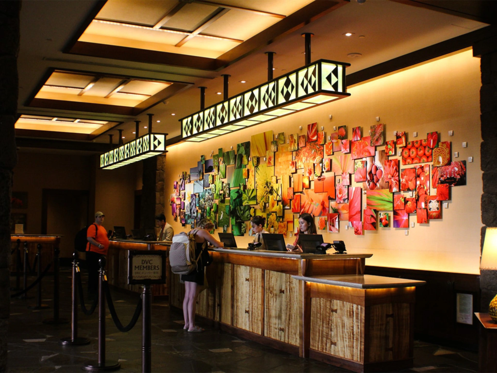 Front desk check-in lobby counter with a colorful photo mosaic wall at Aulani Disney Vacation Club Villas.