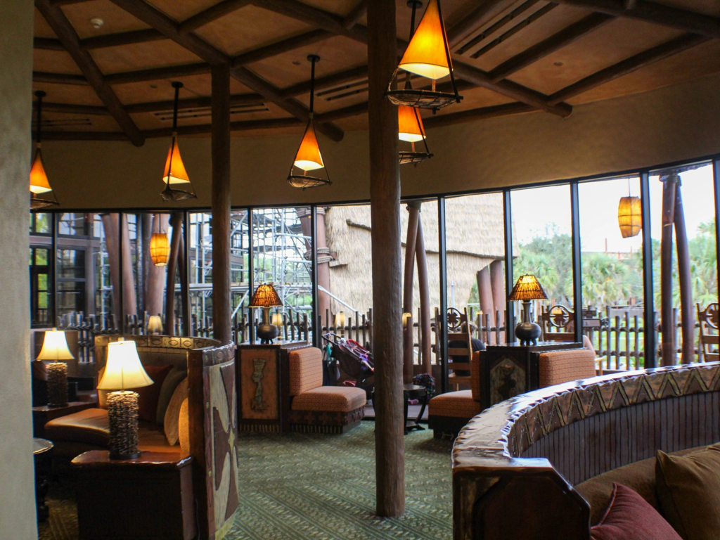 A curved, cozy indoor lounge area with patterned booths, soft lighting, and large viewing windows at the lodge.