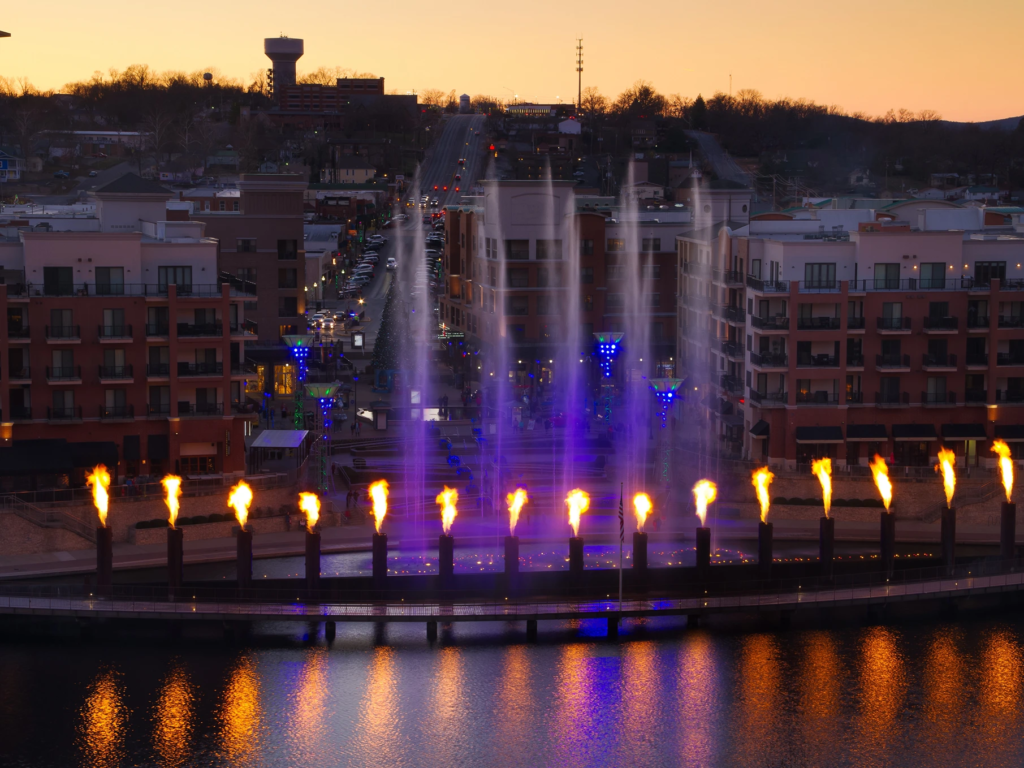 Branson Landing fountains shooting water and fire alongside the water at sunset.