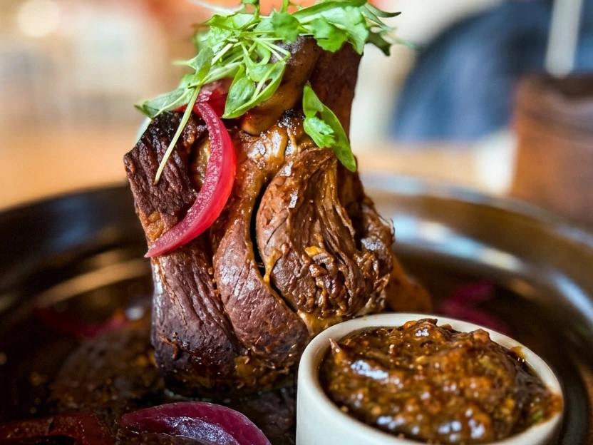 Slow-roasted pork shank with pickled red onions, representing the premium fare at the Best Downtown Disney Restaurants.