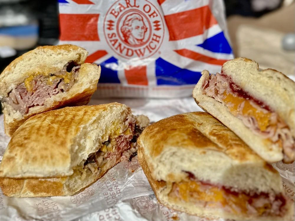 Halved artisan warm sandwiches filled with sliced meats and melted cheese from Earl of Sandwich in Disney Springs.