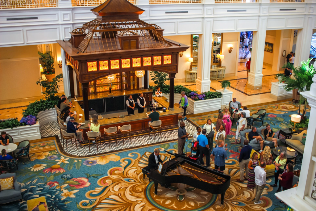 The elegant main lobby of Disney's Grand Floridian Resort featuring a grand piano and a central bar.