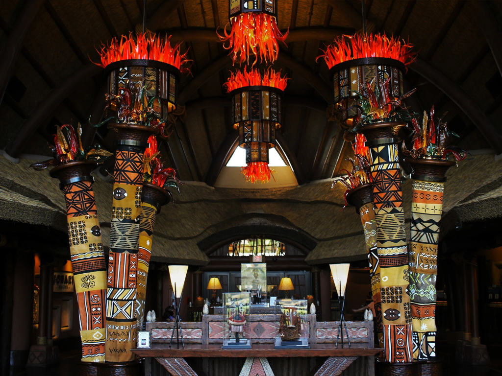 The ornate lobby at Kidani Village featuring striking African-inspired pillars and warm orange chandeliers.