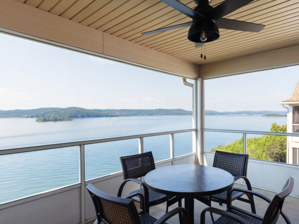 Screened balcony with patio table and chairs overlooking the water at Westgate Branson Lakes Resort.