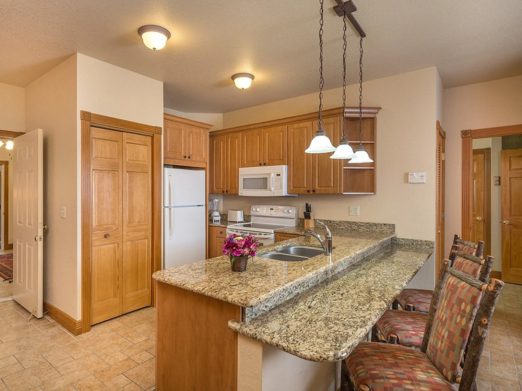 Fully equipped kitchen at Westgate Branson Woods Resort with granite counters and wood cabinetry.