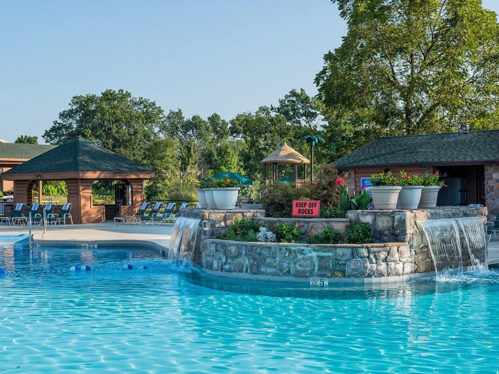 Refreshing swimming pool at Westgate Branson Woods Resort with a multi-tiered stone waterfall.