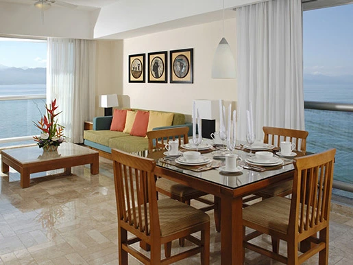 Spacious Mayan Palace lobby featuring round brown seating, polished marble floors, and a modern chandelier.
