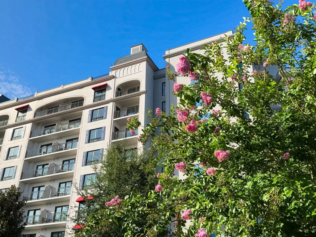 Disney's Riviera Resort behind blooming crape myrtle trees, one of the newer resorts DVC resale companies handle.