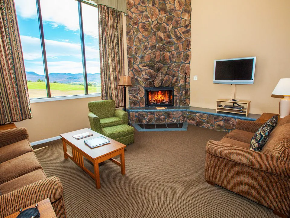 Cozy hotel living room with stone fireplace and mountain views, perfect for romantic getaways in upstate NY.