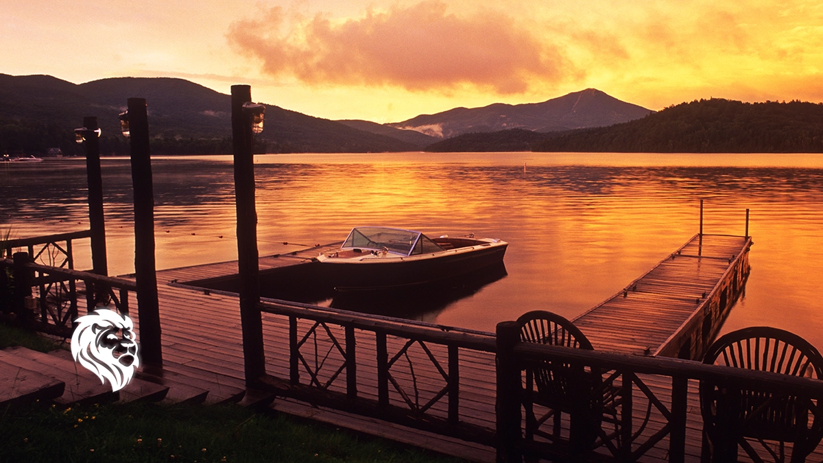 Wooden dock and moored boat at sunset on a calm lake, perfect for romantic getaways in upstate NY.