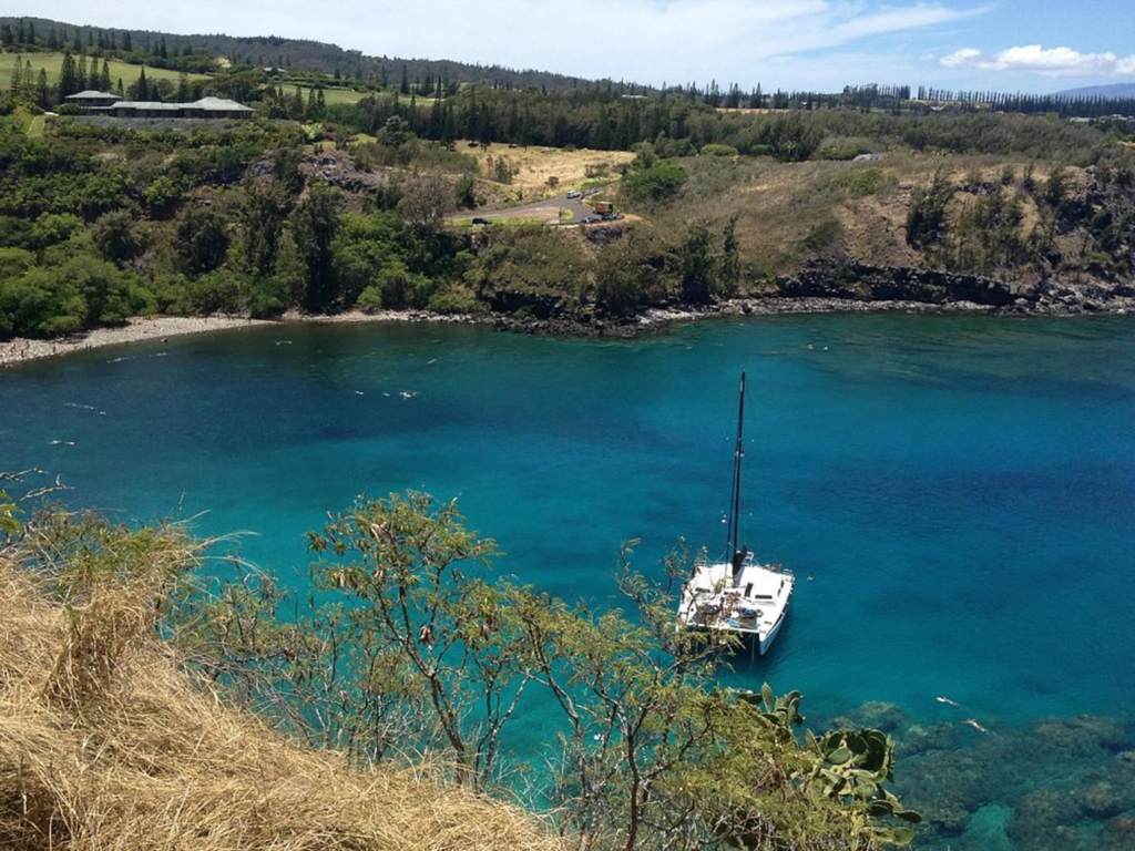 Rocky coastline and calm blue waters of Honolua Bay, a marine preserve and one of the best places to snorkel in Maui.