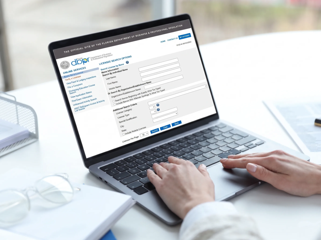 Person researching how to cancel my timeshares Boca Raton on a laptop showing the Florida DBPR licensee search website